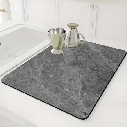 Gray marble-patterned mat on a kitchen counter with a sink in the background