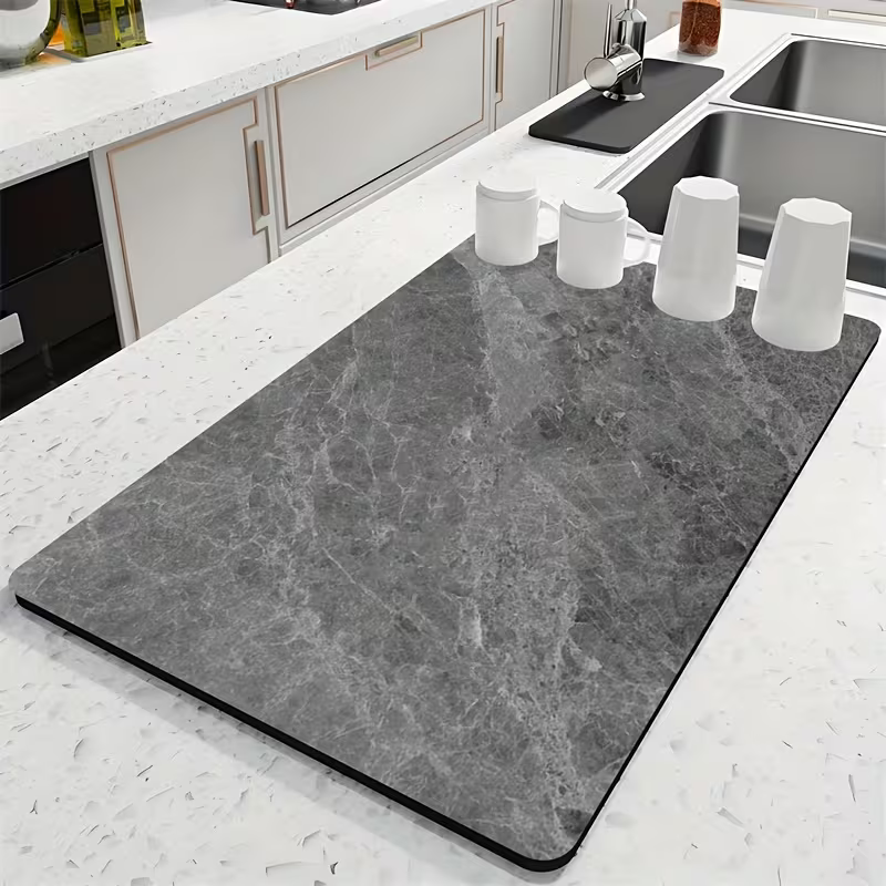 Gray marble-patterned mat on a kitchen counter with white cups.